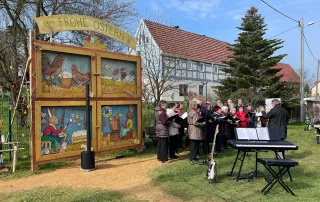 Chorgemeinschaft Reinhardtsdorf-Schöna e.V. - Ostersingen im Park 2023 - der Chor auf dem österlich geschmückten Dorfplatz